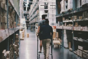 Warehouse worker navigating through inventory shelves, representing how ERP for SMBs streamlines inventory management and operations