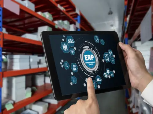 Warehouse manager using a tablet with ERP software to streamline operations for small businesses